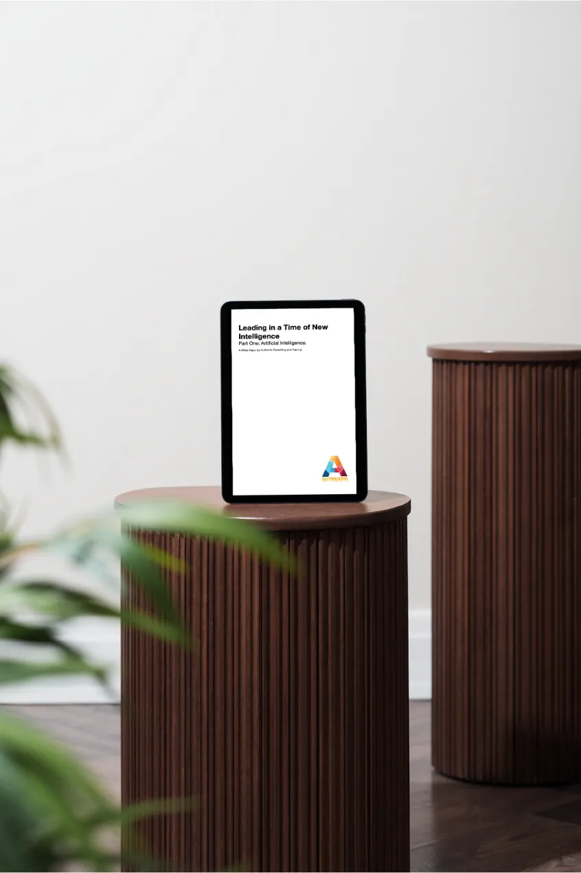 Authentik's White Paper on an iPad which is standing up on a log, slightly obscured by a plant.