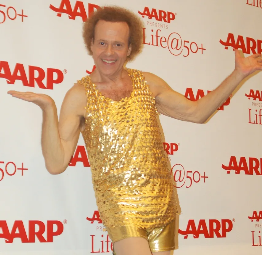 A photo of Richard Simmons in his typical outfit - shorts and a tank top with shiny sequins.
