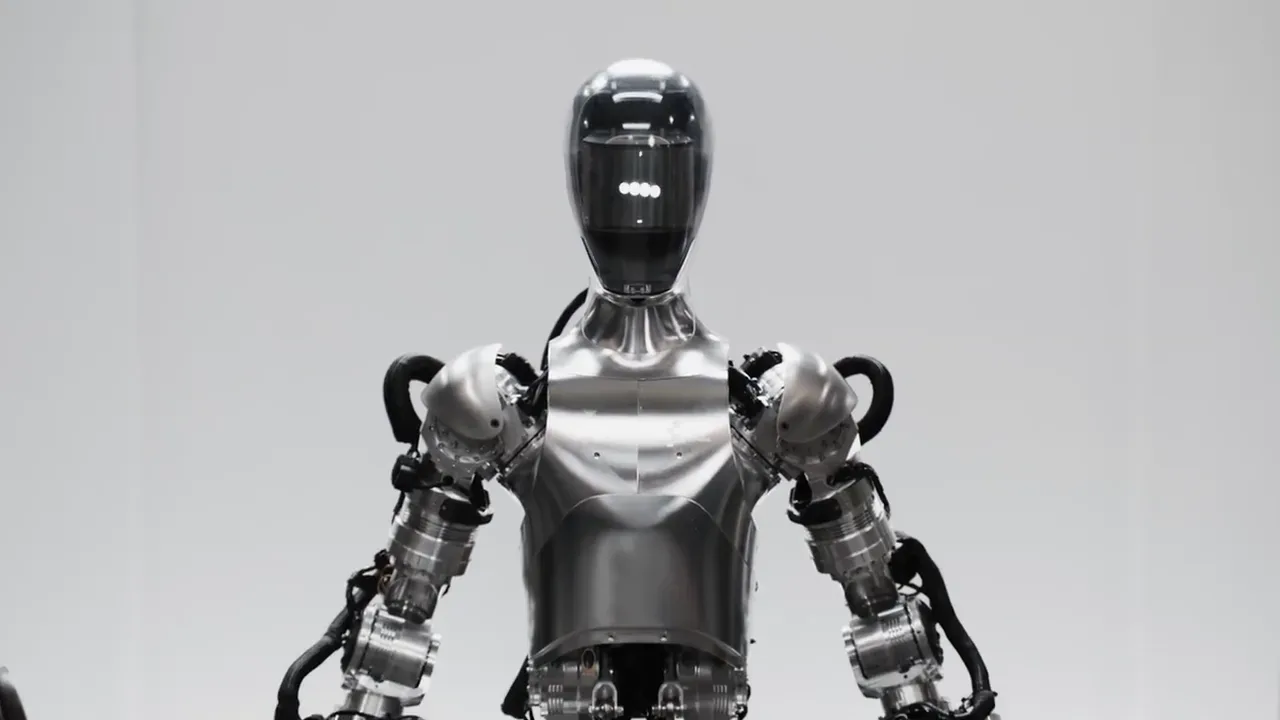 A silver humanoid robot with a dark visor for a face, standing against a plain white studio background.