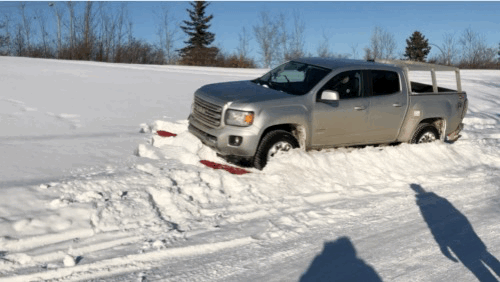 A silver truck stuck in snow