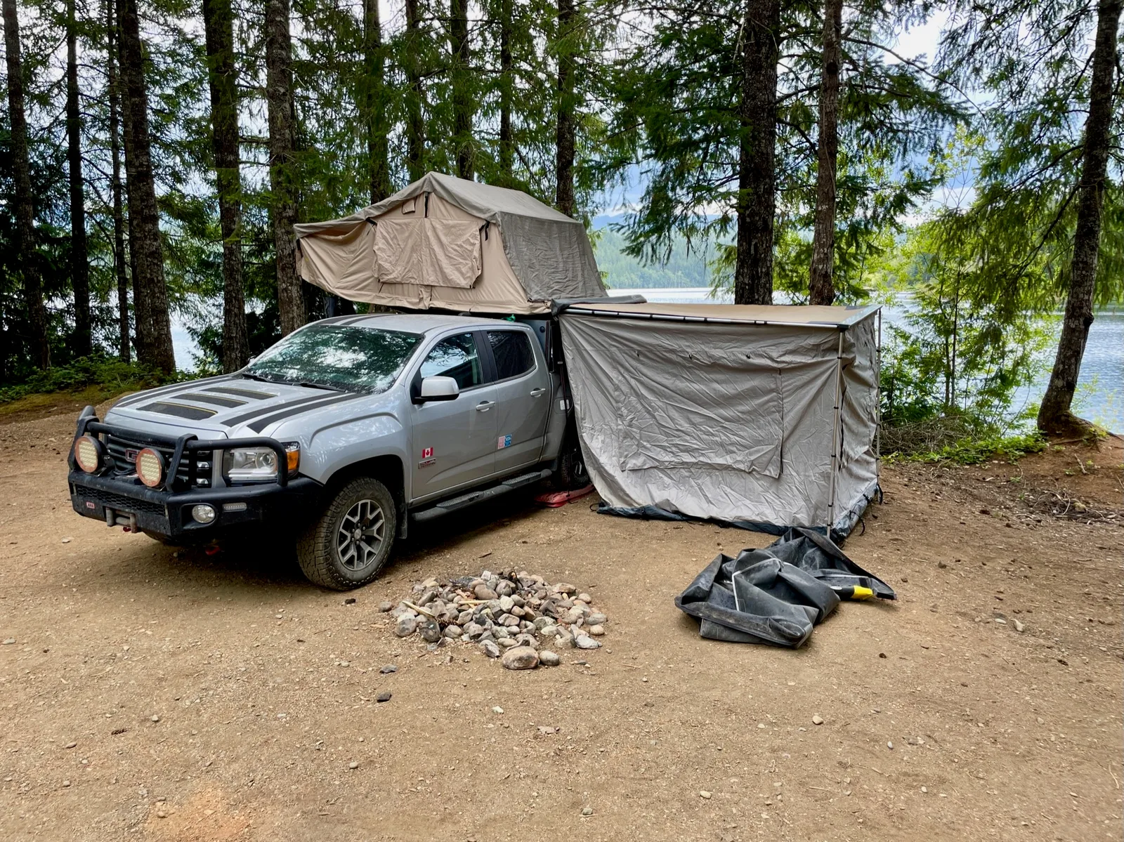 A truck with a tent on top and an awning off the side.