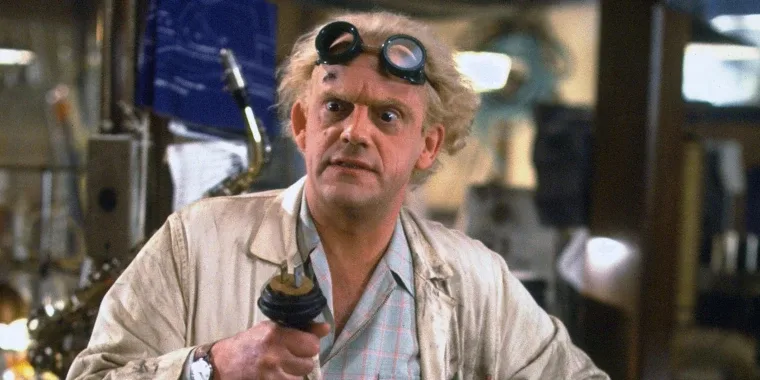 Doc Brown from Back to the Future, goggles pushed up on his forehead, looking startled.
