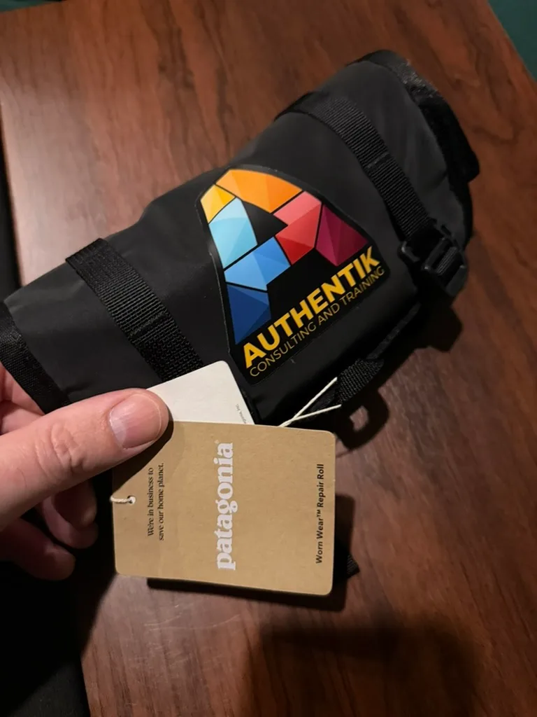 A Patagonia sewing kit in the form of a tool roll with the Authentik multicoloured geometric "A" on it.
